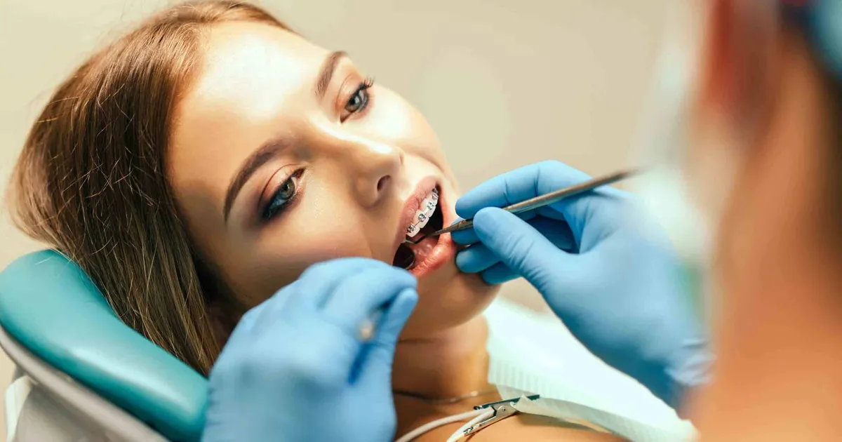 Pacjentka na fotelu dentystycznym podczas badania jamy ustnej