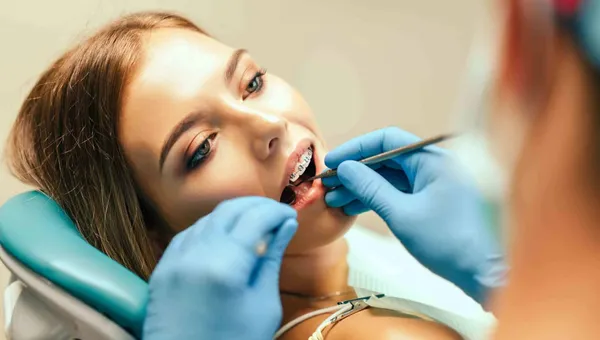 Pacjentka na fotelu dentystycznym podczas badania jamy ustnej